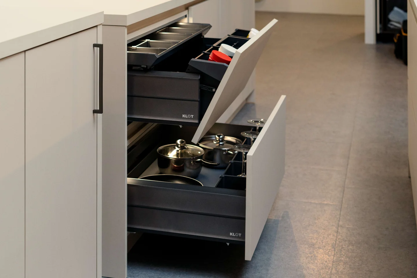 Open KLOT kitchen storage drawers with separate spaces for utensils, dishes and pots